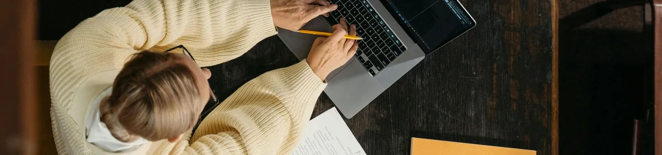 Femme travaillant sur un ordinateur portable dans un bureau avec un cahier à côté d'elle